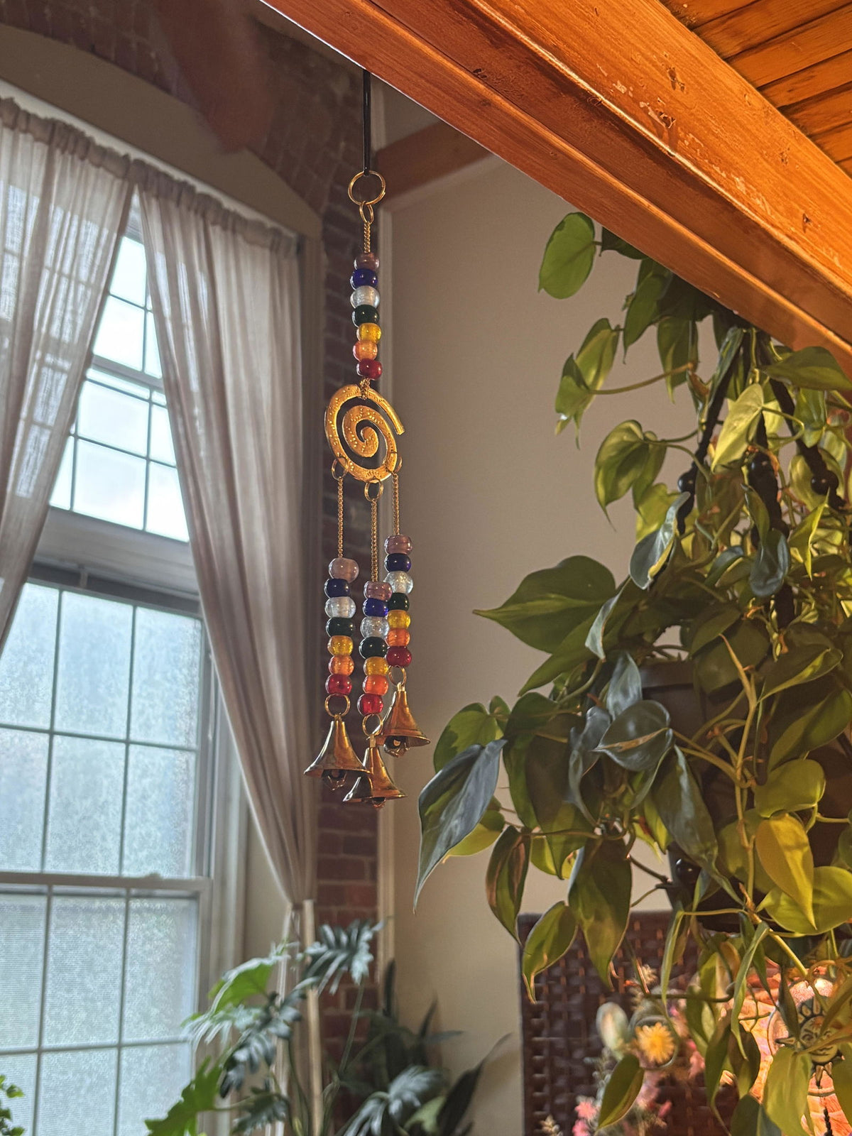 Chakra spiral wind chime hanging in a sunny window, customer photo