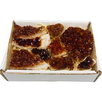 Flat of raw Brazilian citrine points in varying shades of yellow to deep amber gold in a cardboard box