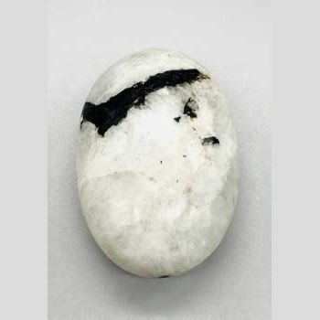 Close-up of a polished Rainbow Moonstone palm stone with iridescent flashes, used for balance and intuition enhancement