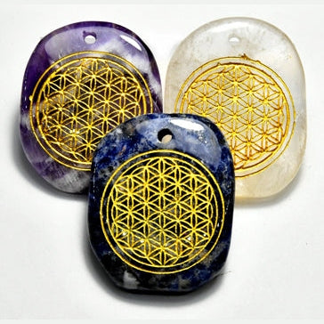 Set of three Flower of Life worry stones with holes, carved in Amethyst, Clear Quartz, and Lapis Lazuli, featuring gold geometric designs and suitable as pendants.