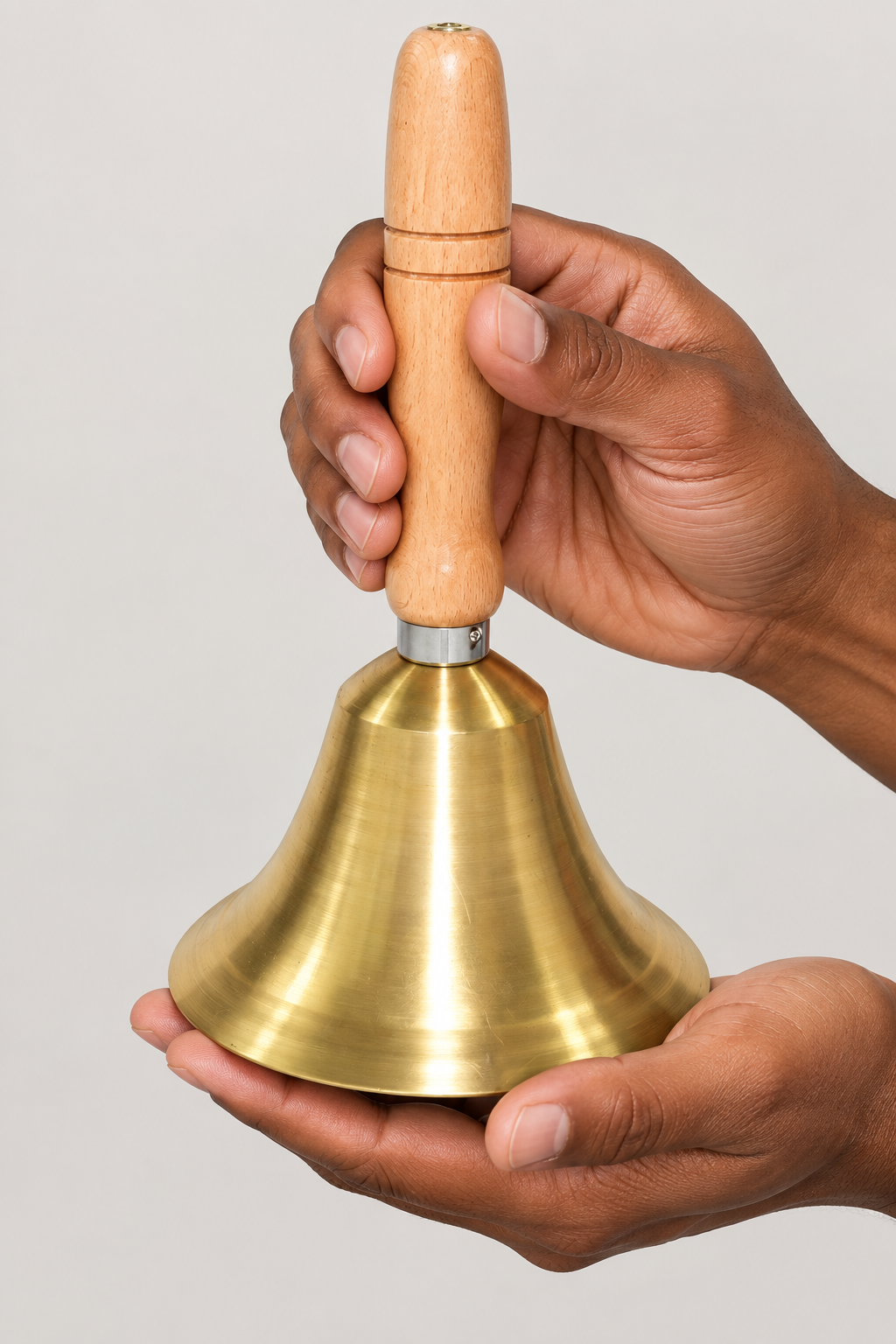 Brass and wood bell supported in hands