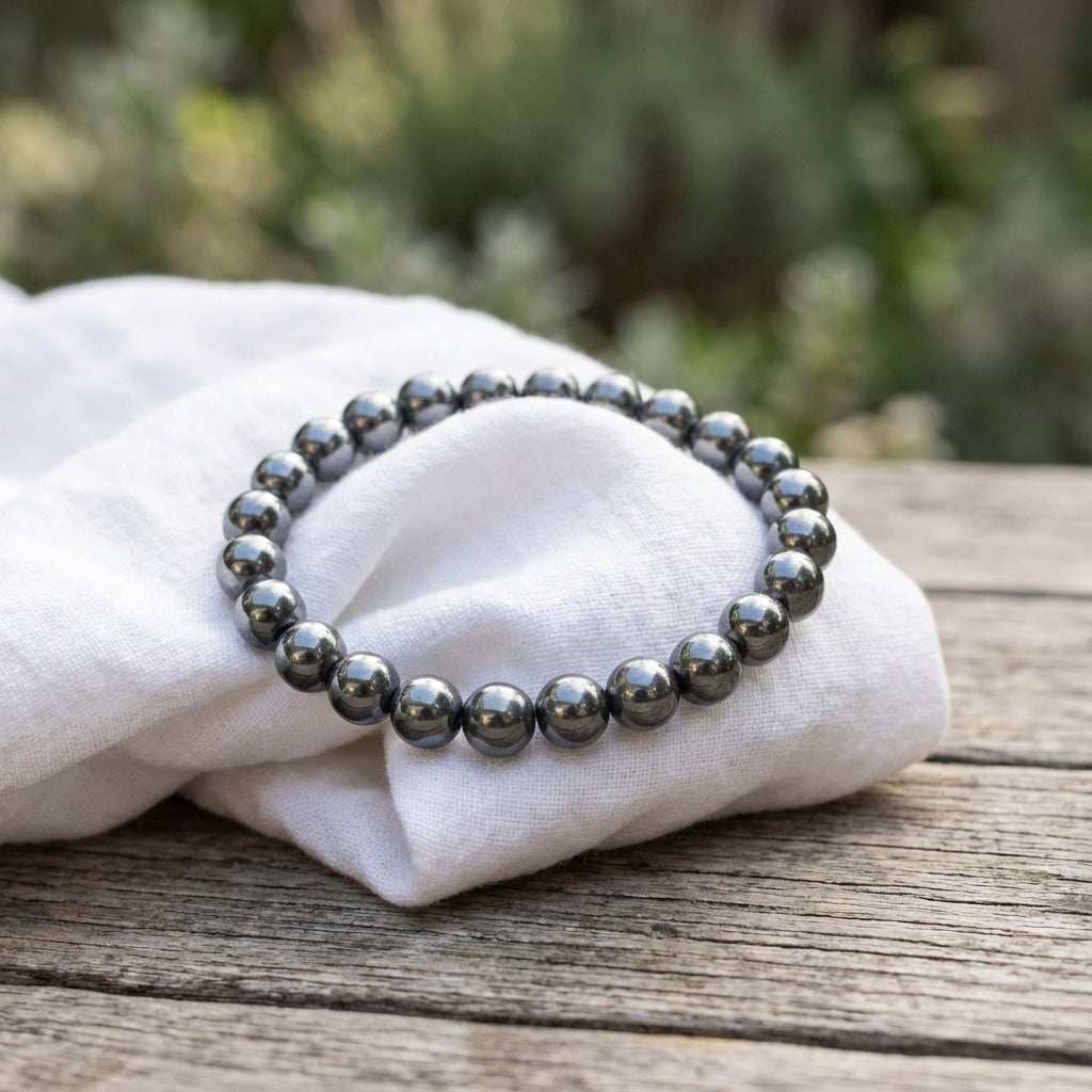 You will be generating high-quality product photos for an online stores product page. The product images should closely match the original products.
Here is the prompt (IMPORTANT!): """An artistic, lifestyle-inspired composition of the 8mm Hematite G