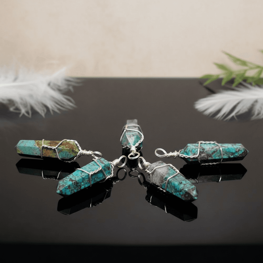 Visualize a luxurious product display scene with a set of five wire-wrapped Chrysocolla crystal point pendants elegantly arranged on a reflective black surface. Illuminate the scene with HDR studio lighting to accentuate the vibrant blue and green hues, cr