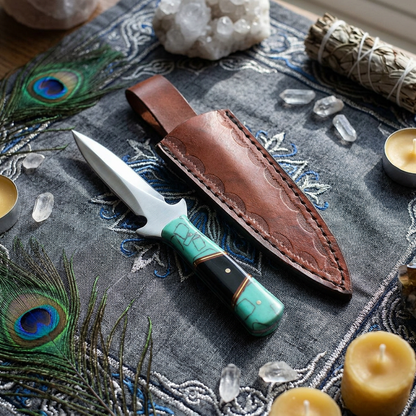 Overhead view of a 7-inch turquoise and black handled athame on a textured altar cloth, showcasing fine details amidst a ceremonial environment.