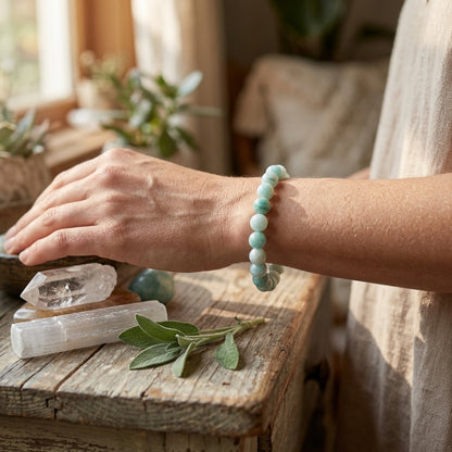 Petite Amazonite bracelet on a wooden wrist model, surrounded by natural elements like leaves and crystals.