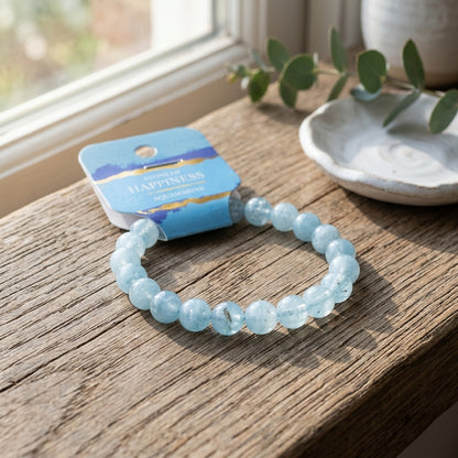 Still life of a tiny aquamarine bracelet resting on a rustic wooden table with natural daylight, showcasing micro-details and tranquil colors.