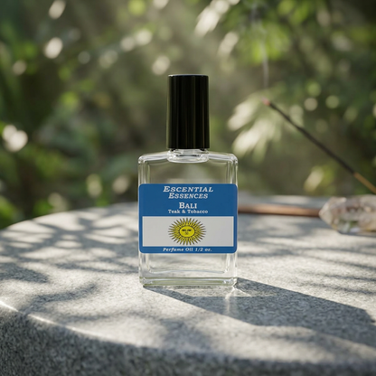 Close-up of Bali perfume oil bottle on polished stone with sunlight filtering through tropical foliage, emphasizing rich amber hue.