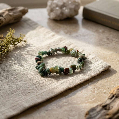 Bloodstone chip bracelet displayed on linen cloth in natural daylight showing micro-texture.