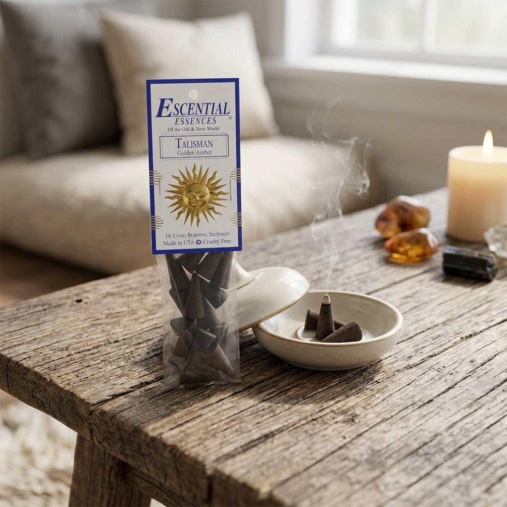 Diminutive golden amber incense cone in a ceramic dish, surrounded by crystals and sage in a meditative, earthy space.