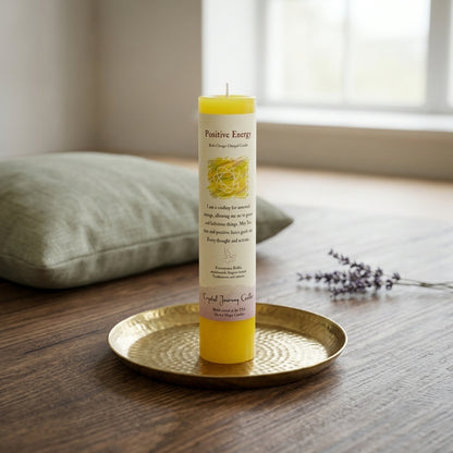 Reiki-charged yellow pillar candle on a wooden table in a peaceful meditation room with soft daylight and minimal decor.