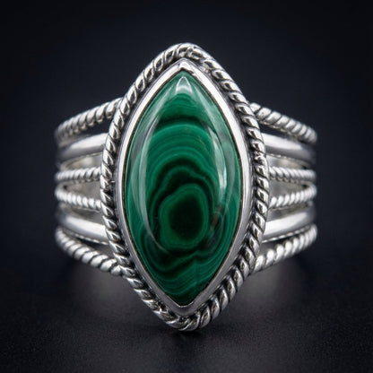 Create a high-resolution, studio-quality image of the 'size 11 Malachite ring' featuring a close-up macro shot taken with a 100mm macro lens, set against a sleek, dark matte background. Utilize softbox lighting from the top left to highlight the polished m