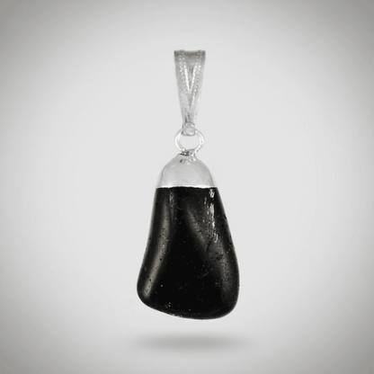 A highly detailed, photorealistic close-up of a glossy black tourmaline tumbled pendant, suspended against a soft, neutral background. The pendant is illuminated by a diffused daylight studio light, creating subtle highlights on its smooth, rounded surface