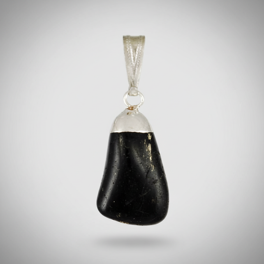 A highly detailed, photorealistic close-up of a glossy black tourmaline tumbled pendant, suspended against a soft, neutral background. The pendant is illuminated by a diffused daylight studio light, creating subtle highlights on its smooth, rounded surface