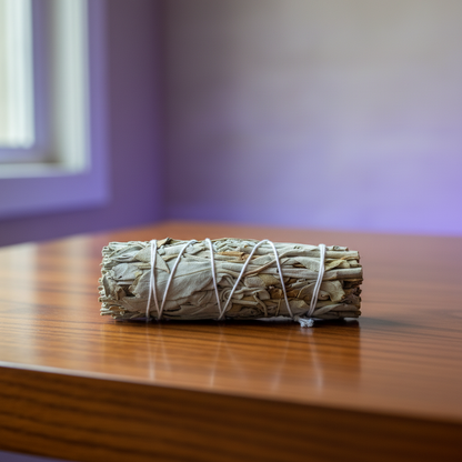 A highly detailed, photorealistic scene capturing a California White Sage Smudge Stick, 3 Inch, placed on a smooth, polished wooden altar within a modern spiritual sanctuary. The background features softly blurred, ambient LED lighting with hues of violet 