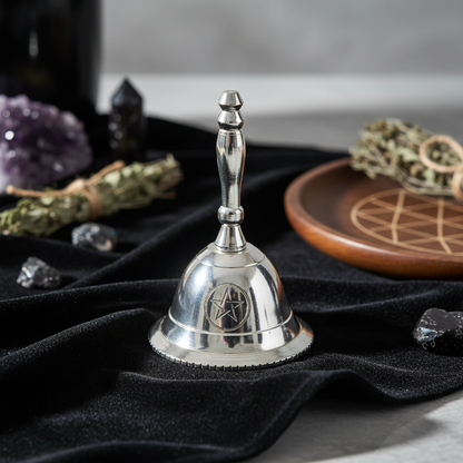 Close-up shot of the Altar Bell with Pentagram Design, 2 1/2 inches, set against a textured, dark velvet cloth in a contemporary spiritual space. HDR studio lighting brings out the reflective quality of the brass, with rim lighting to accentuate its contou