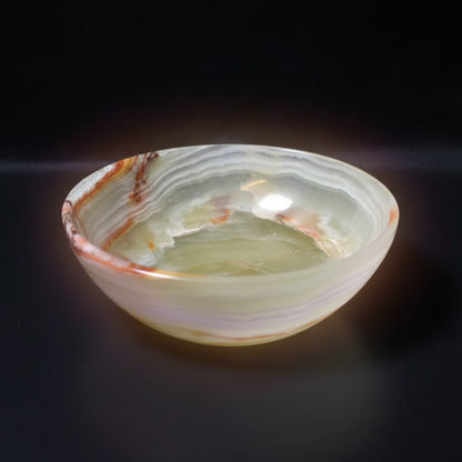 A highly detailed professional studio shot of the Onyx Stone Bowl, captured from a top-down angle with a macro lens at 85mm focal length, emphasizing the smooth, polished surface and deep matte black texture of the onyx. The bowl is set against a subtle, d