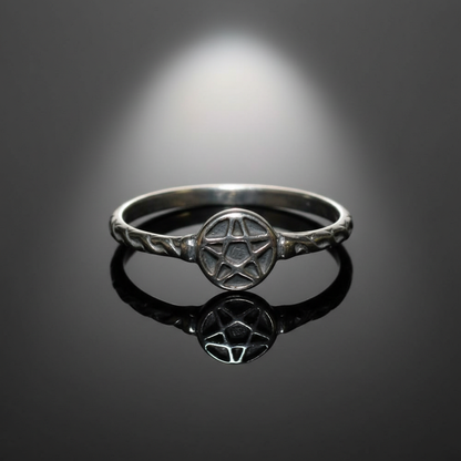 Create a highly detailed, studio-quality image of a sterling silver pentagram ring in size 6, positioned centrally on a reflective black mirror surface with soft diffusion sweeping across the scene, spotlighted by a softbox light source from above to highl