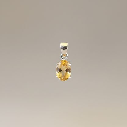 Capture a close-up, macro-style shot of the 'Citrine pendant silver' suspended gently in mid-air, illuminated by a softbox light that accentuates the vibrant, sunny hues and crystalline facets of the Citrine gemstone. Use a shallow depth of field with a 10