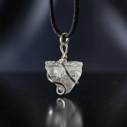 Create a highly detailed, cinematic studio shot of an Apophyllite wire wrapped pendant, captured from a slightly overhead angle using a macro lens with a 100mm focal length, showcasing the intricate craftsmanship of the wire wrapping. The pendant is suspen