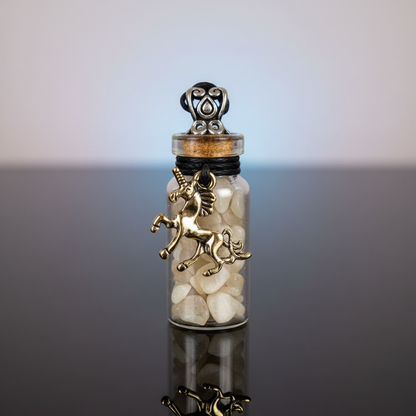 A highly detailed, studio-shot image of the Moonstone Chips in Bottle with Unicorn Necklace, captured with a macro lens using a softbox lighting setup to emphasize clarity and brilliance. The scene features a close-up of the glass vial, filled with shimmer