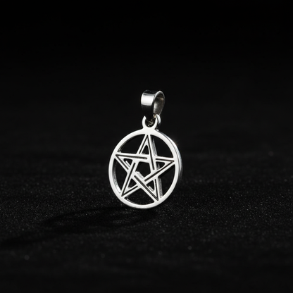 Capture a highly detailed, studio-lit close-up of a Sterling Silver Pentacle Pendant, shot from eye level with a focus on the intricate pentacle design suspended against a deep, matte black background. Use a softbox light to softly diffuse gentle highlight
