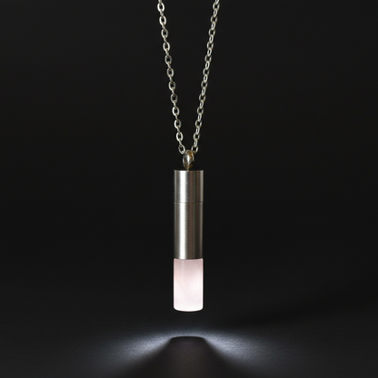 Create a hyper-realistic studio shot of the Rose Quartz chamber with chain, capturing the pendant suspended against a smooth, matte black background to emphasize its soft, translucent pink hue. Use a softbox light positioned at a 45-degree angle to create 