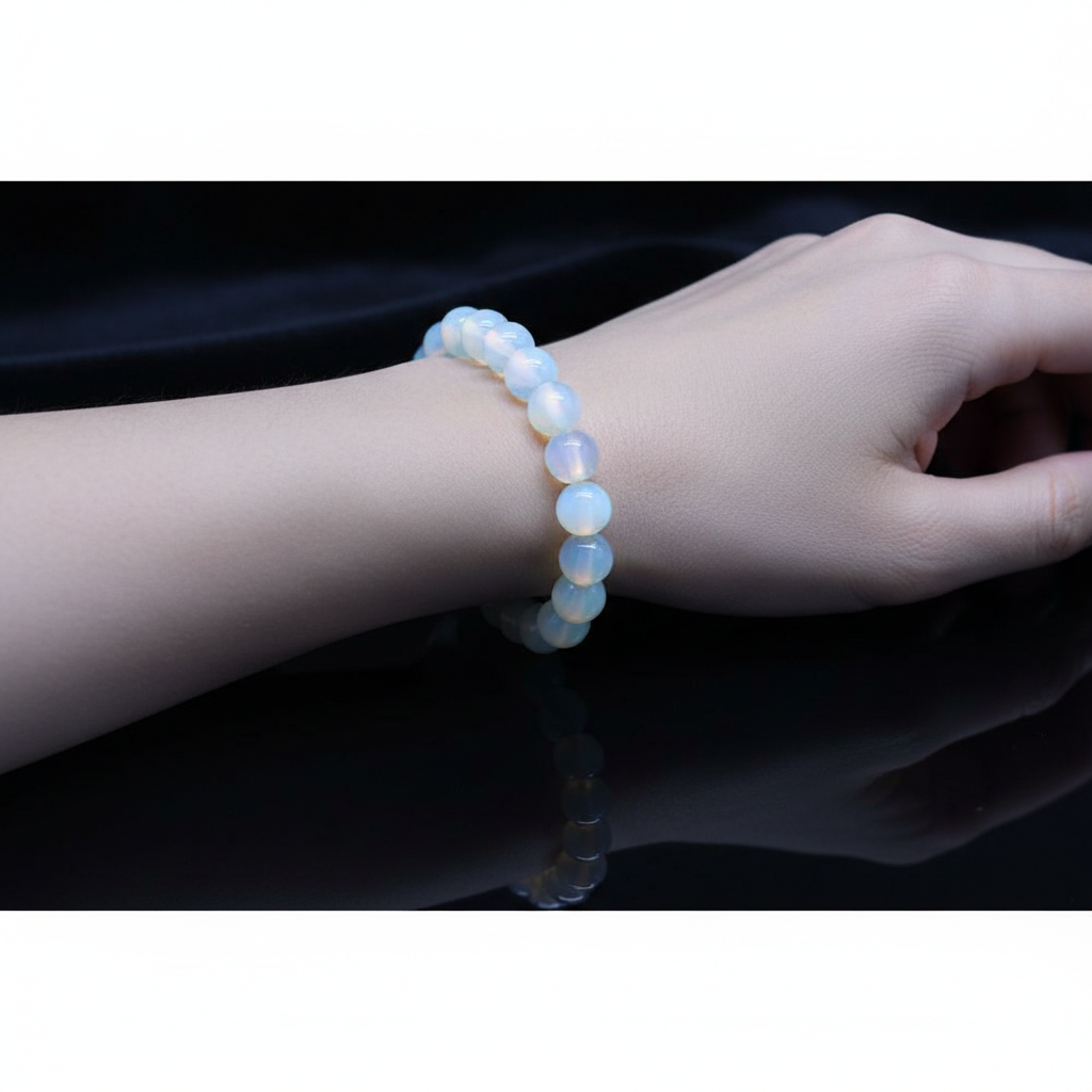 Capture a close-up, highly detailed shot of the Opalite Beaded Bracelet, 8mm, elegantly draped around a softly illuminated, ethereal model's wrist. The scene is styled in a high-end jewelry studio, with HDR studio lighting that highlights the luminous, sem