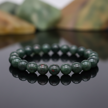 Capture a close-up, macro shot of the Bloodstone Bracelet, 8mm, showcasing the rich, deep green hues and distinctive blood-red specks within each polished bloodstone bead. Use HDR studio lighting with softbox diffusion to highlight the natural translucency