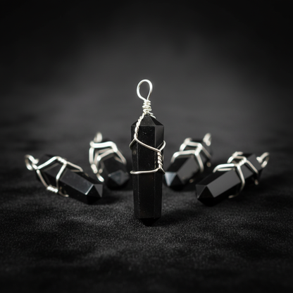 Capture a highly detailed, studio-style close-up shot of the 'Wire Wrapped Black Obsidian Pendant, Set of 5' arranged elegantly on a reflective black velvet cloth, illuminated by softbox lighting to accentuate the glossy textures of the obsidian and intric