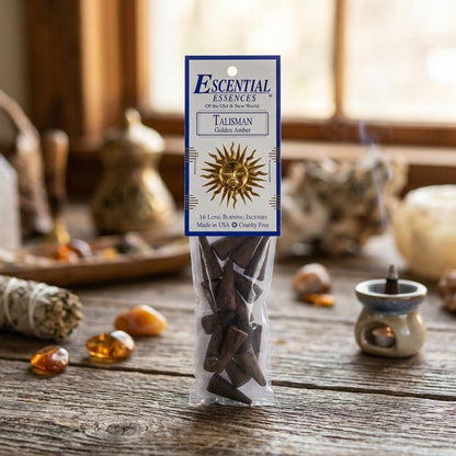 Close-up of a golden amber incense cone with textured surface and soft glow in a cozy, natural room setting.