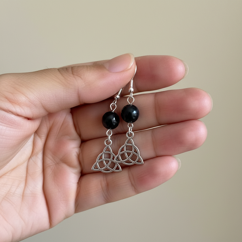 Hematite Triquetra Earrings, held in hand