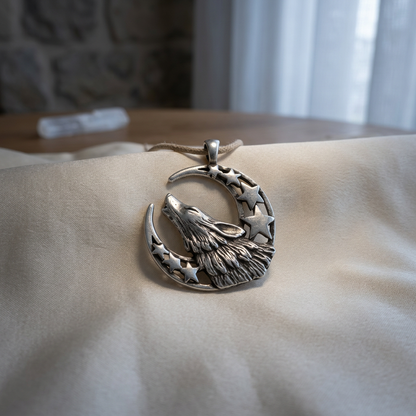 Photorealistic small pewter amulet with crescent moon and star symbols, resting on silk cloth, illuminated by soft moonlight in a sacred space.