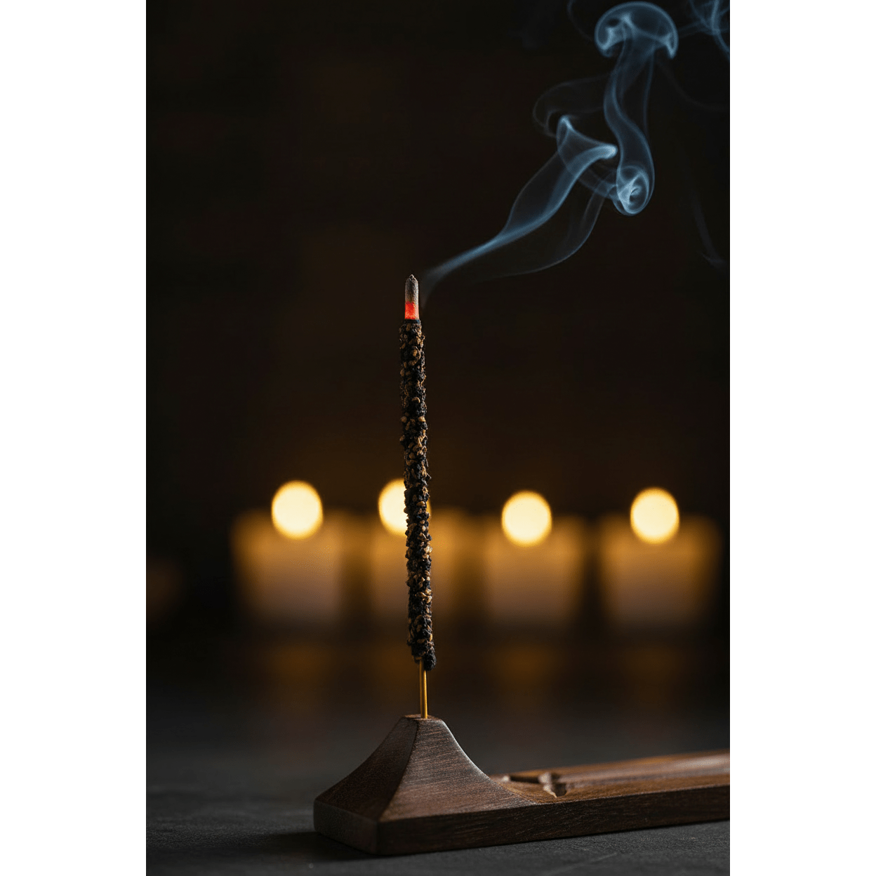 Single Sonavi Myrrh incense stick burning in a wooden holder with glowing ember and smoke curling upward against warm golden bokeh background