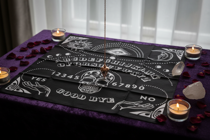 Ouija Board Mat on a velvet-draped altar table with a rose gold pendulum, tea lights, rose petals, and quartz point
