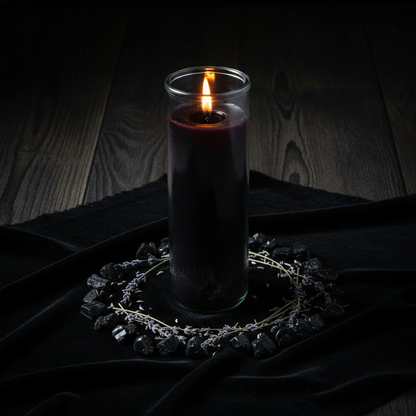 Black 7-day jar candle on black velvet cloth surrounded by black tourmaline stones and dried lavender in a ritual circle