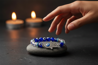 Evil Eye Clear Quartz Bracelet on dark slate with candlelight, Mediterranean hand reaching in