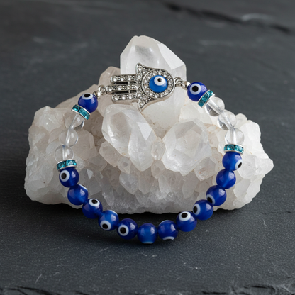 Evil Eye Clear Quartz Bracelet draped over white quartz crystal cluster on dark slate