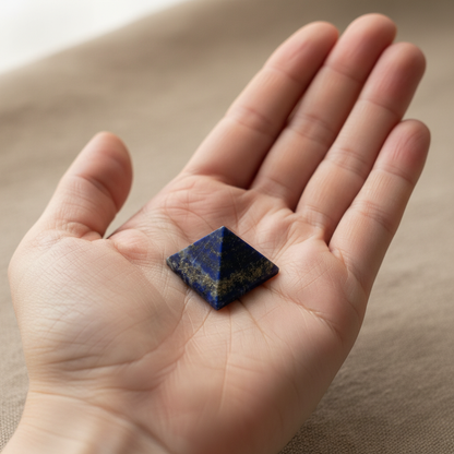 Lapis lazuli crystal pyramid, 1 inch wide, resting in an open palm