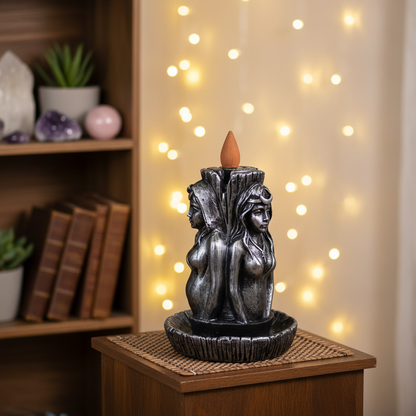 Maiden, Mother, Crone backflow incense burner styled in a cozy meditation nook with fairy lights and crystals