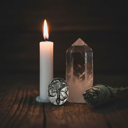 Clover Pocket Stone on dark wooden altar with candle, sage, and quartz crystal