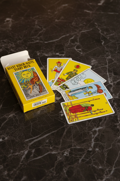 Giant Rider-Waite Tarot Deck yellow box open with tarot cards fanned out on dark marble surface
