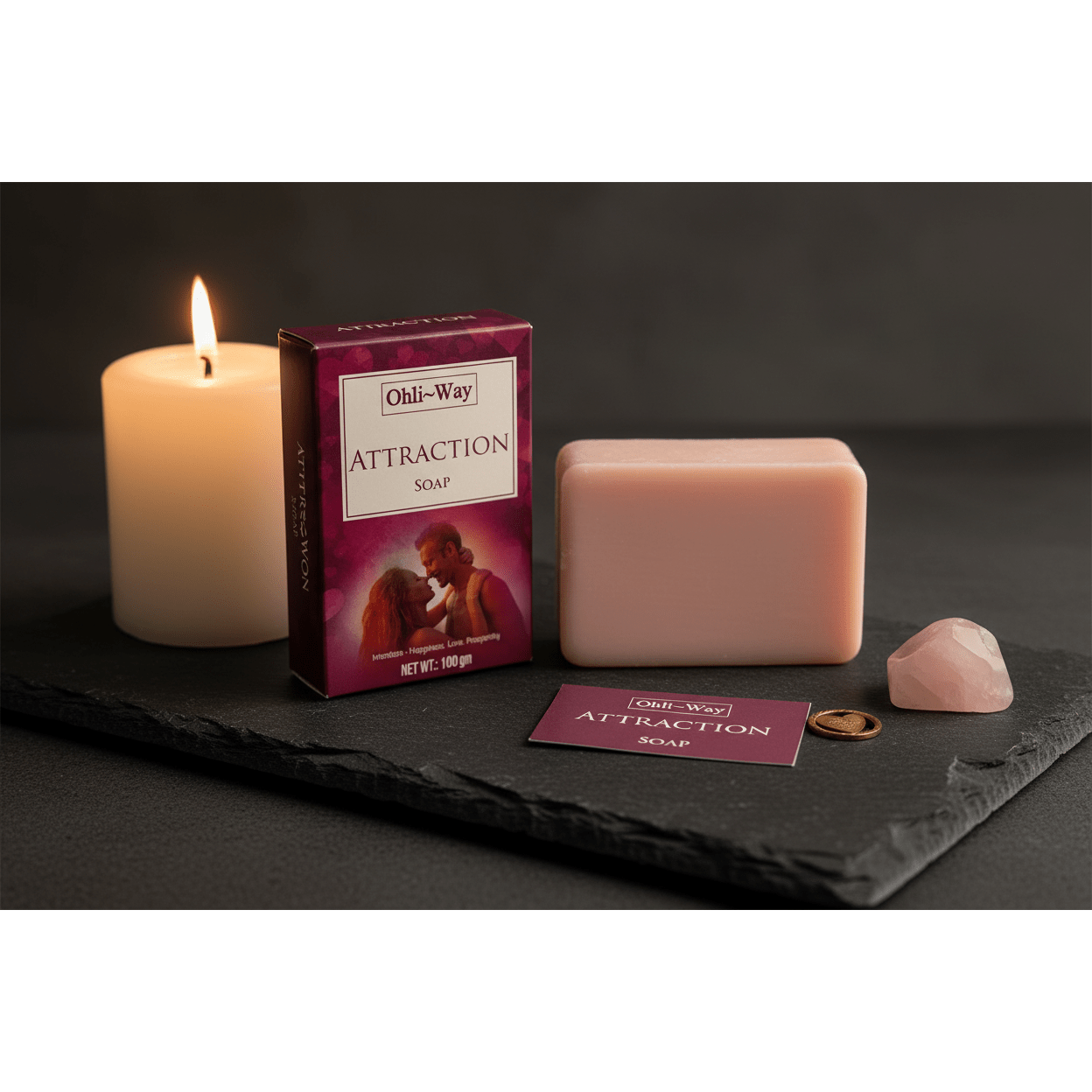 Ohli-Way Attraction Soap set with pink bar, burgundy box, gold heart charm and prayer card on dark slate with lit candle and rose quartz crystal