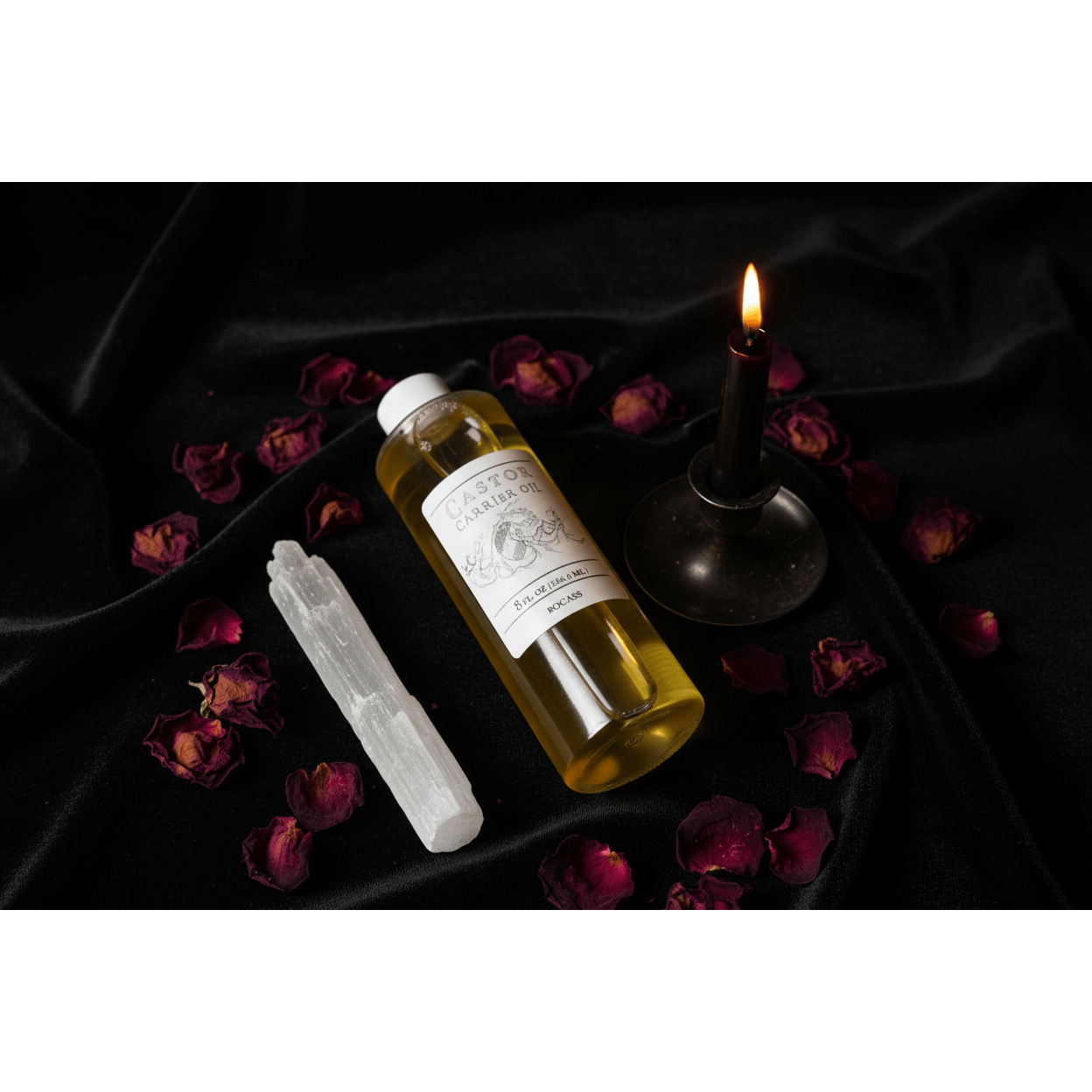 Castor Carrier Oil 8oz bottle on dark velvet cloth with lit black taper candle, selenite wand, and dried rose petals