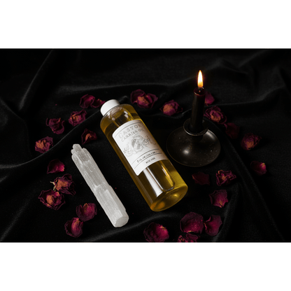 Castor Carrier Oil 8oz bottle on dark velvet cloth with lit black taper candle, selenite wand, and dried rose petals