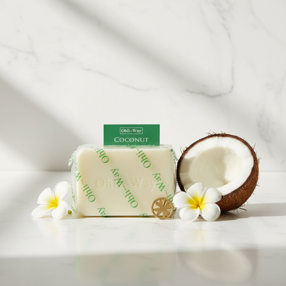 Ohli~Way Coconut Spiritual Cleansing Soap 100g bar on white marble with halved fresh coconut and white tropical flowers
