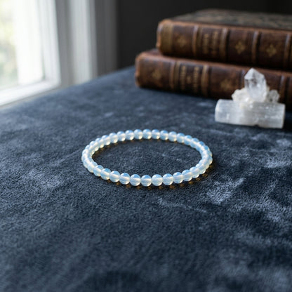 Opalite beaded bracelet, 4mm, resting on deep-toned velvet, capturing its glow, micro-texture, and refined elegance in a tranquil setting.
