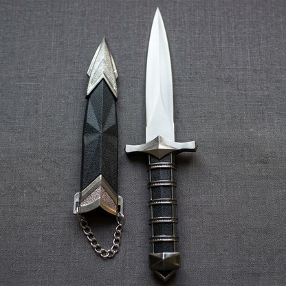 Close-up of a 9 1/2 inch medieval athame with engraved stainless steel blade, detailed craftsmanship highlighted by natural sunlight on a textured fabric.