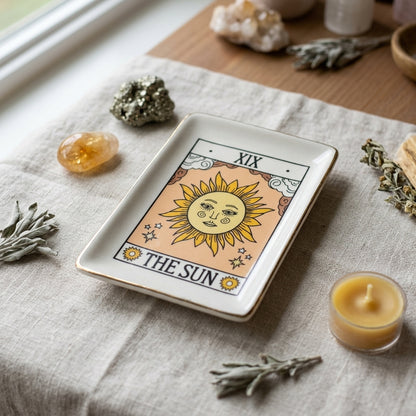 Close-up of Sun Tarot Energy Dish with crystals on neutral fabric, emphasizing ceramic craftsmanship and gold details.