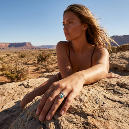 Model showcasing size 6 turquoise spiny oyster ring on finger in sunlit desert scene, emphasizing delicate craftsmanship.