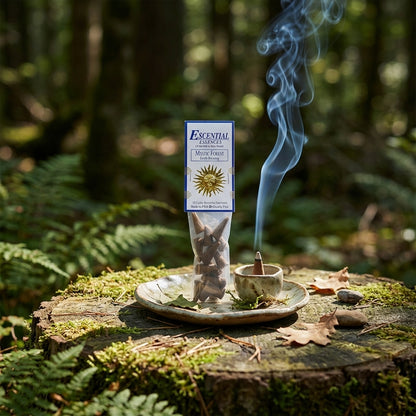 Small Mystic Forest incense cone in ceramic holder on rustic wooden table in lush forest setting.